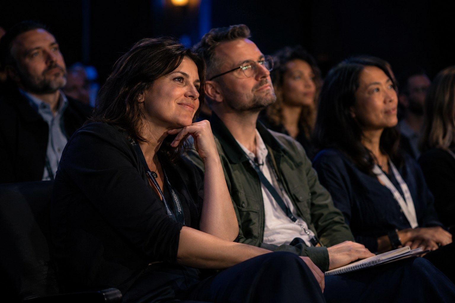 Audience members leaning in and listening